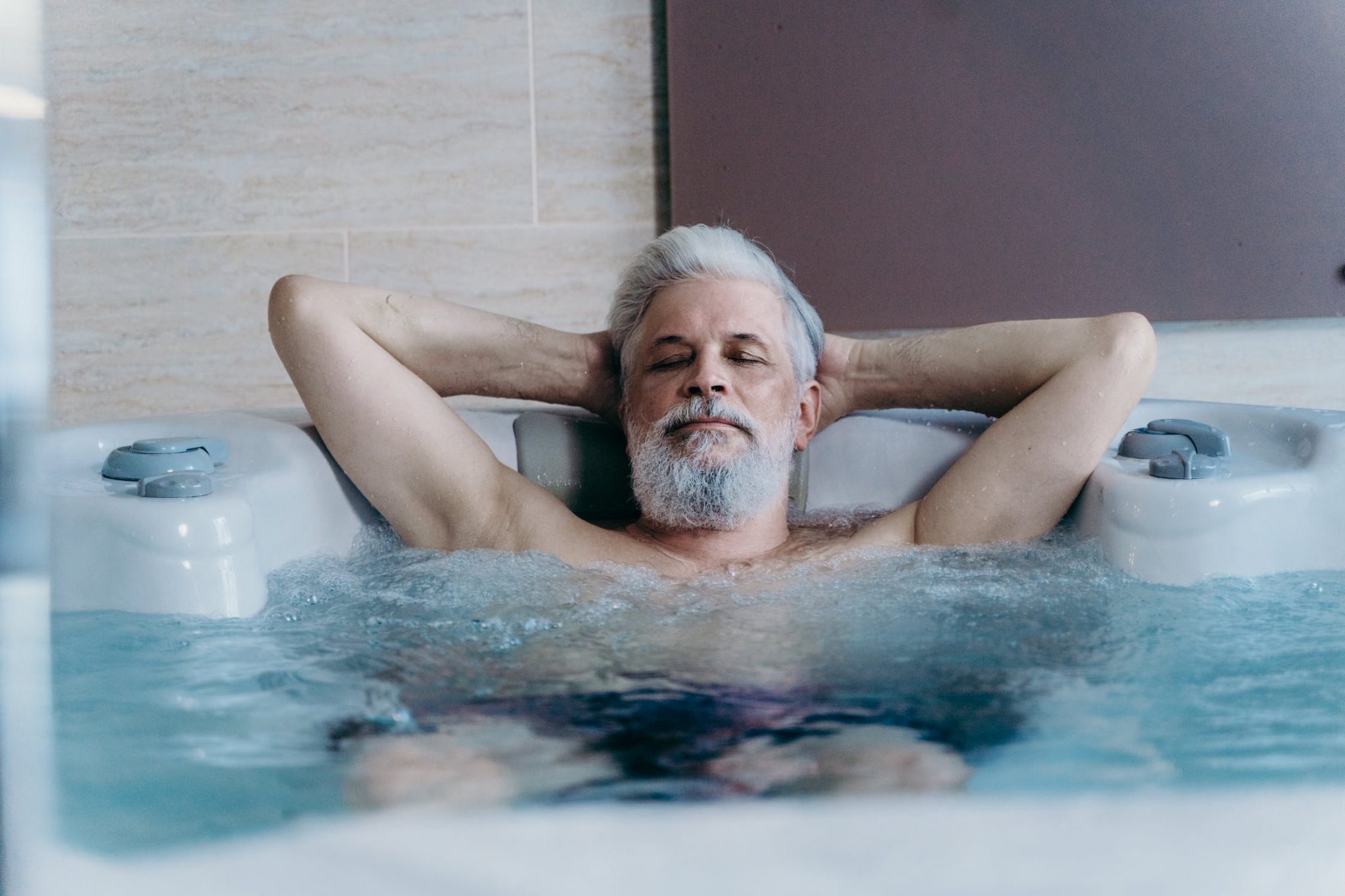 Persoon ontspant in een jacuzzi met perfecte temperatuur ingesteld voor comfort en welzijn