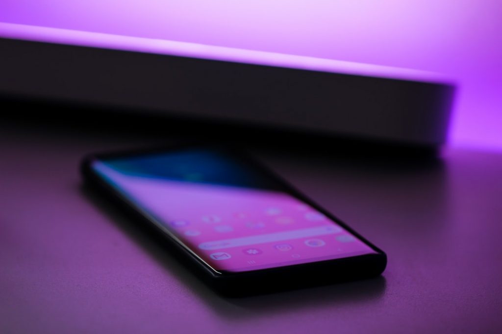 Moderne smartphone met smartphonehoesje trends zoals 5G-technologie, contactloos betalen en voice assistant functies