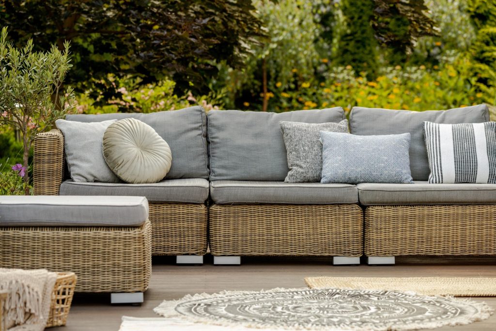 Grijze kussens op moderne wicker loungebank in luxe buitenruimte voor ultiem comfort en stijl