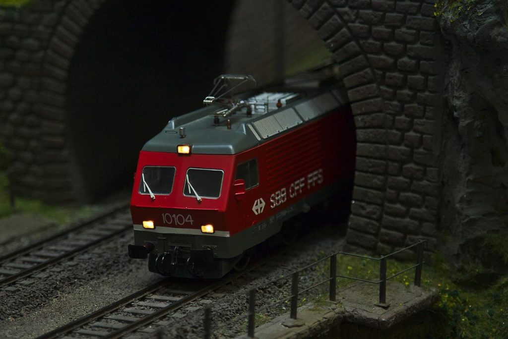Moderne modeltreinbaan met digitale besturing en gedetailleerde landschapsscènes, illustrerend hoe innovatie en technologie m